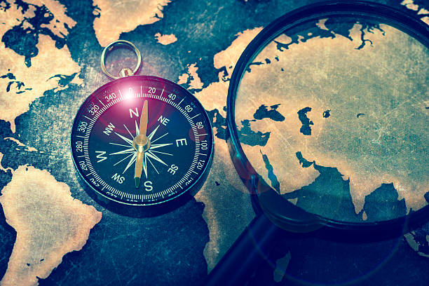 istock Compass and magnifying glasses on grunge world map 625892218