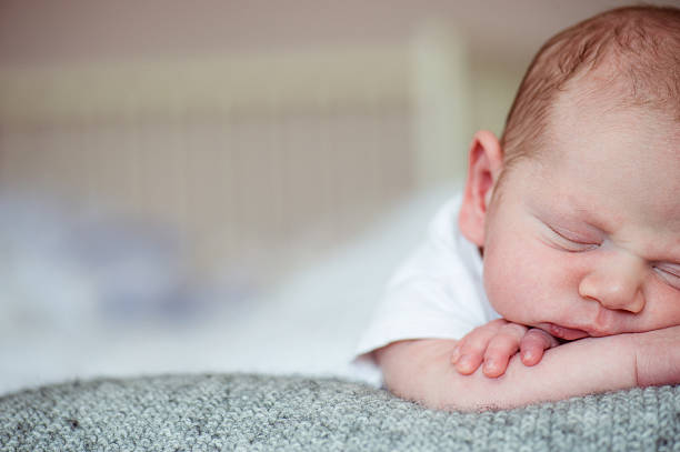 istock Newborn baby boy lying on bed, sleeping, close up 625892614