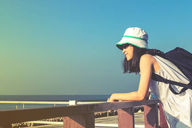 młoda podróżnicza stojąca na drewnianym molo z błękitnym niebem - tranquil scene sky road street zdjęcia i obrazy z banku zdjęć