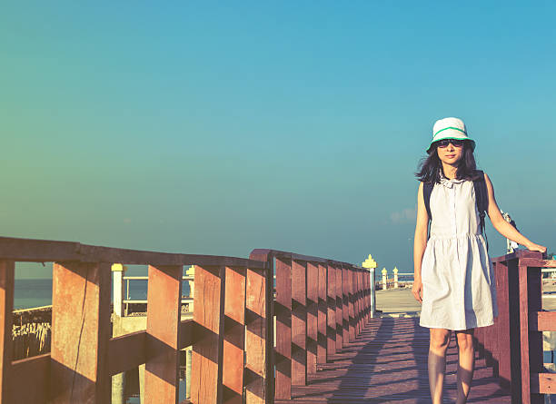 młoda podróżnicza stojąca na drewnianym molo z błękitnym niebem - tranquil scene sky road street zdjęcia i obrazy z banku zdjęć