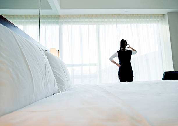 Young asian woman on phone in hotel room.