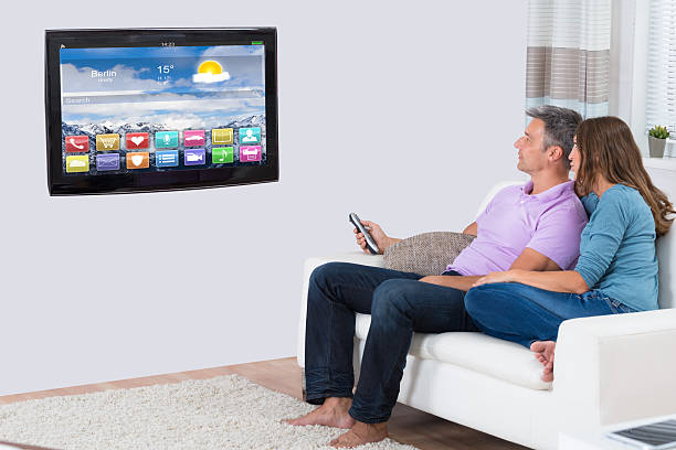 istock Couple Sitting On Sofa Watching Television 625893728