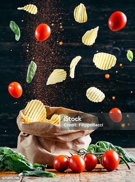 Flying Food Chips And Tomatoes Stock Photo - Download Image Now - Flying, Potato Chip, Food