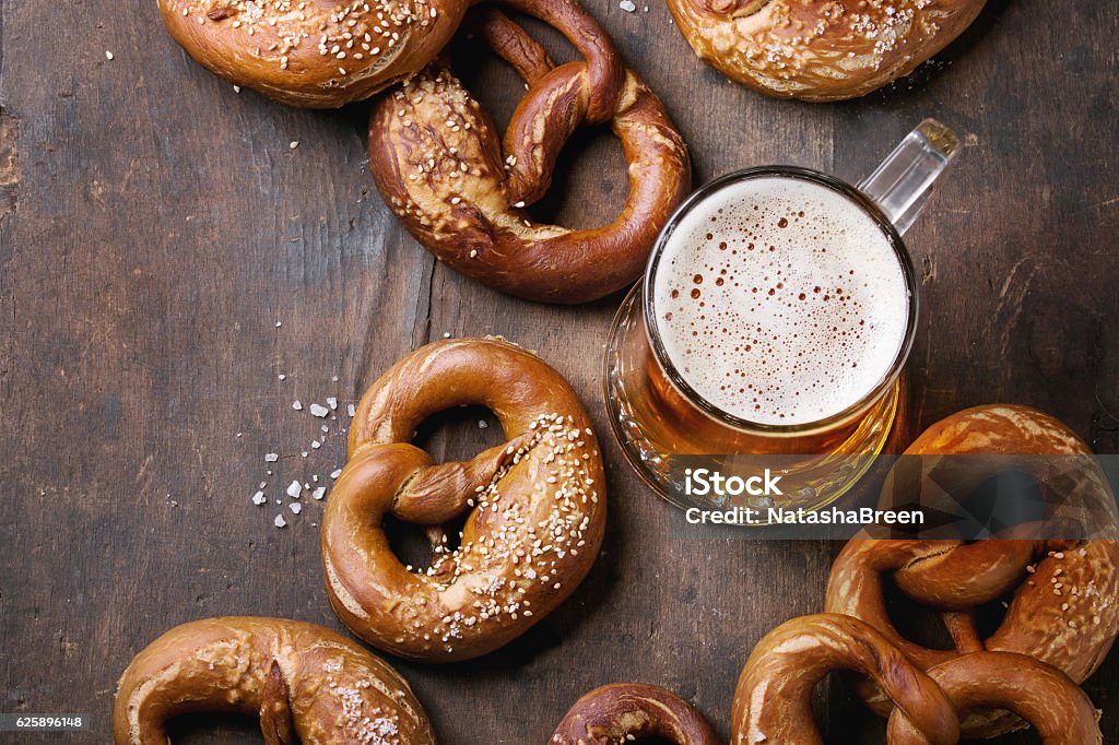 Lager beer with pretzels Glass of lager beer with traditional salted pretzels over old dark wooden background. Top view with space for text. Beer Fest theme Pretzel Stock Photo