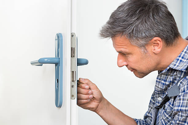 istock Carpenter Fixing Lock In Door With Screwdriver 625902688