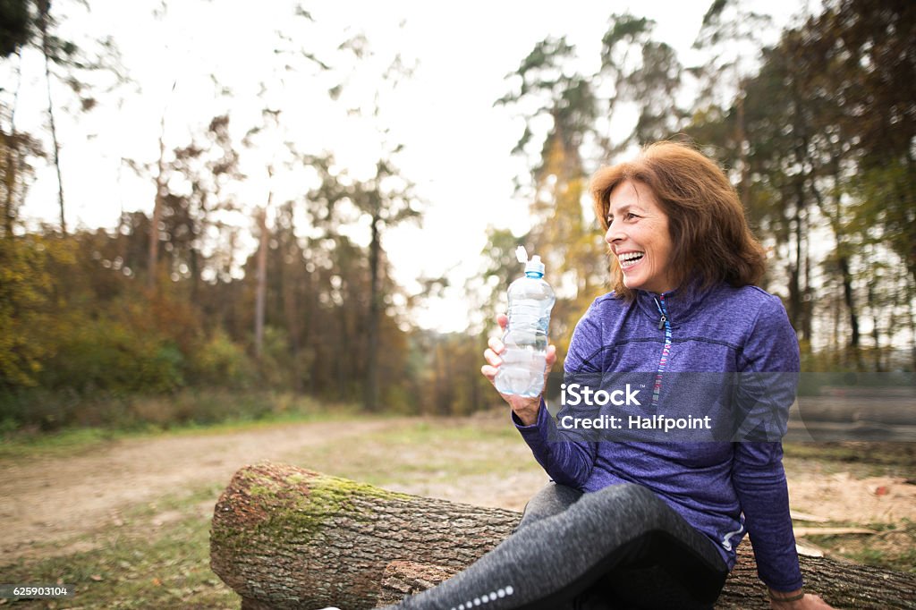 Senior Läufer sitzen auf Holzstämmen, Ruhen, Trinkwasser. - Lizenzfrei Fitnesstraining Stock-Foto