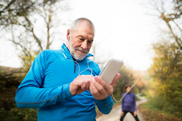 istock Senior runners in nature, stretching. Man with smartphone with e 625904112