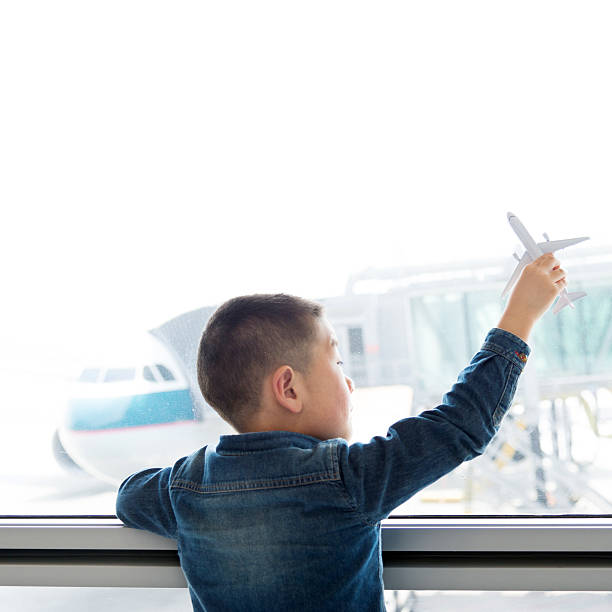 istock Little boy holding a toy plane in airport 625906708