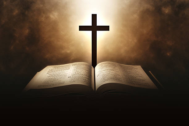 sacra bibbia con una croce e una luce che viene dall'alto - teologia foto e immagini stock