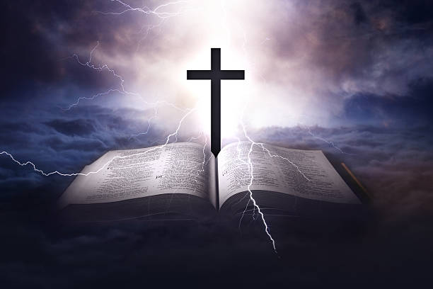 istock Holy Bible with a cross and a light coming from above 625909524