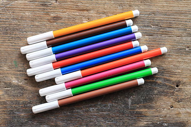 Multicolored felt-tip pens on wooden table stock photo