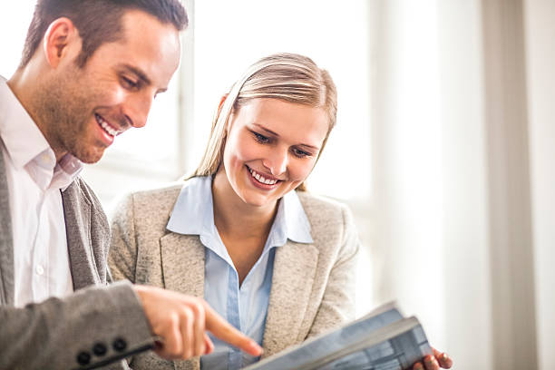 istock Smiling young business people discussing over brochure in office 625910700