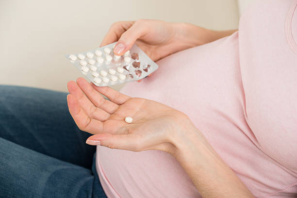 istock Pregnant Woman Taking Vitamin Pill 625912282