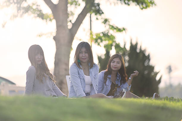 istock Three asian women sit on grass on sunnyday. 625917936