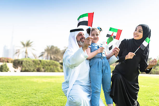 szczęśliwa rodzina emiratu świętować dzień narodowy - flag of the united arab emirates zdjęcia i obrazy z banku zdjęć