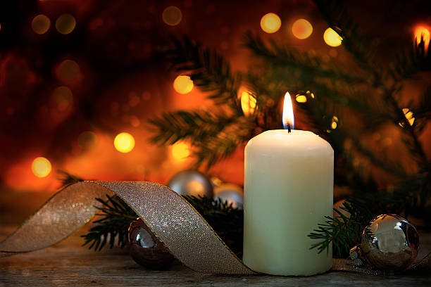 istock burning candle with christmas decoration, dark bokeh background 625927744