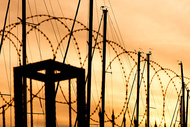 istock ilhouette Razor Wire Fence Against Sky During Sunset 625935742