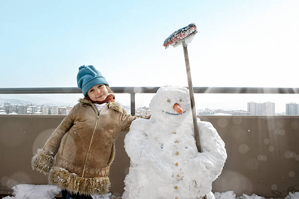 istock little girl and snowman 625947058