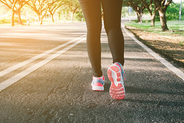 istock Young lady running on road closeup on shoes. 625948574