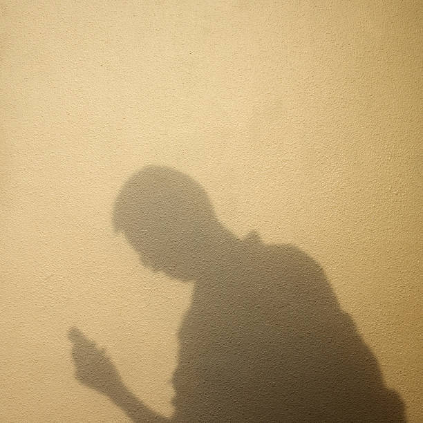 istock Shadow of man holding a phone 625955740