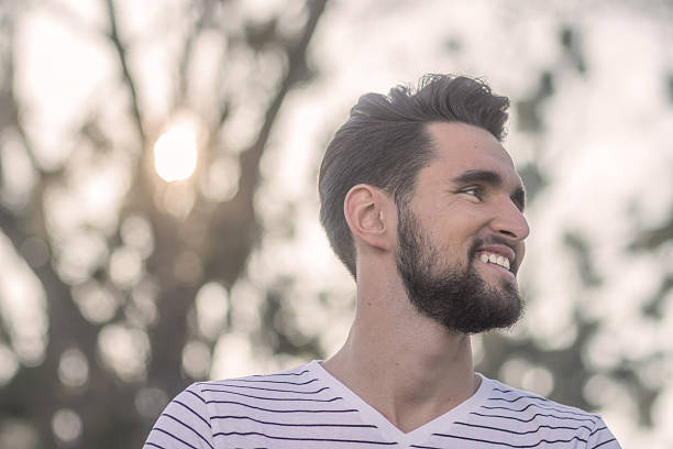 istock Smiling young adult man, looking sideways, head face close up. 625955928