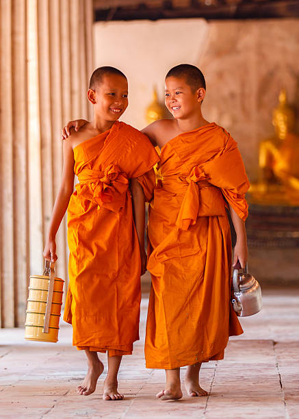 due novizi che camminano e parlano nel vecchio tempio - novice buddhist monk foto e immagini stock