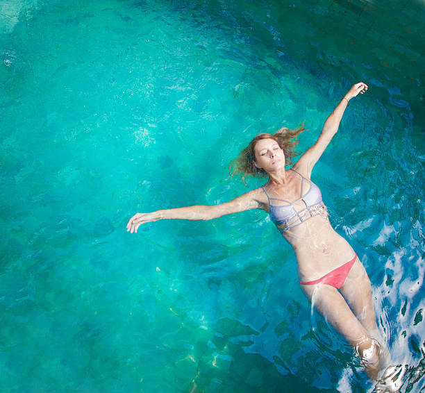istock Young woman relaxing in the pool 625956608