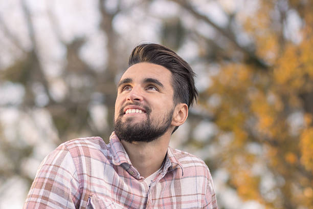 istock Young man smiling looking up head face, close up. 625960028
