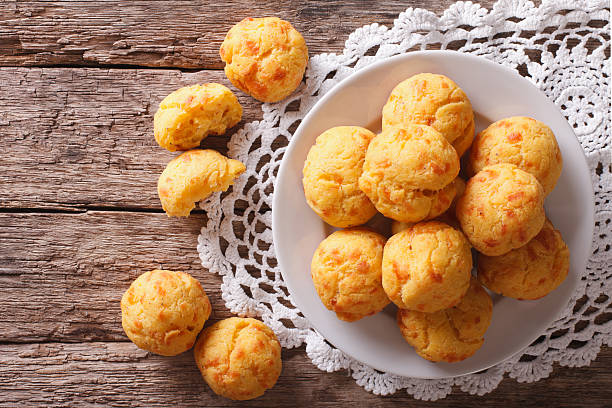 Tasty cheese buns gougere close-up on the table. Horizontal Tasty cheese buns gougere close-up of a plate on the table. horizontal view from above choux pastry photos stock pictures, royalty-free photos & images