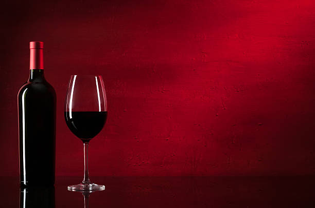 Botella de vino tinto y vidrio  - foto de stock