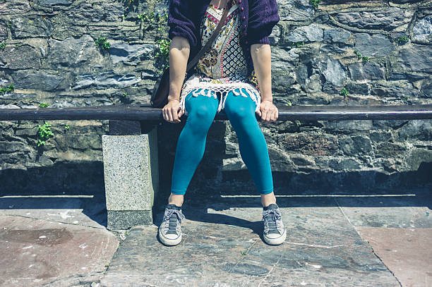istock Woman sitting on a bench outside 625977290