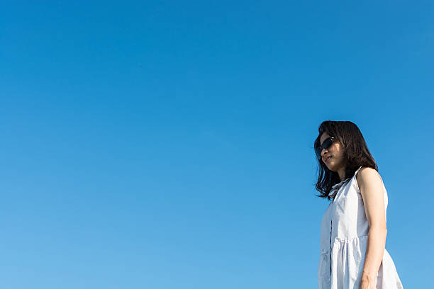 istock pretty asian girl relax with blue sky 625977654
