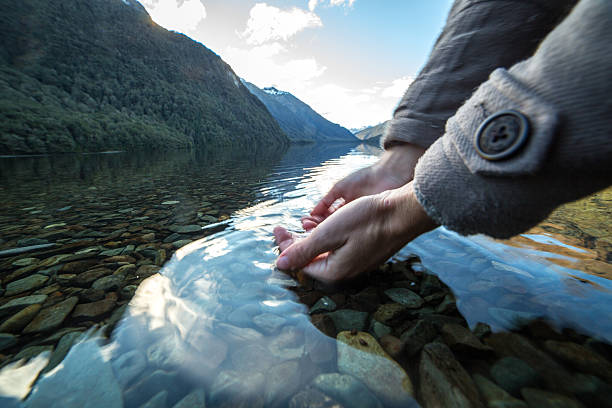 istock Human hand cupped to catch fresh water from lake 625977732