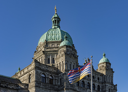 British Columbia Parliament Building BC Flag Victoria BC Canada on a against a blue sky
