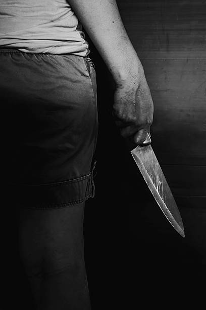 istock Person Holding Knife in the Shadows 625987946