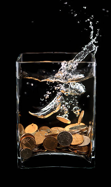 istock coins in water splashes on a black 625989942