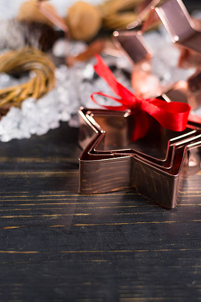 istock Christmas cookies - copper star-shaped cookies cutters on white 625997586