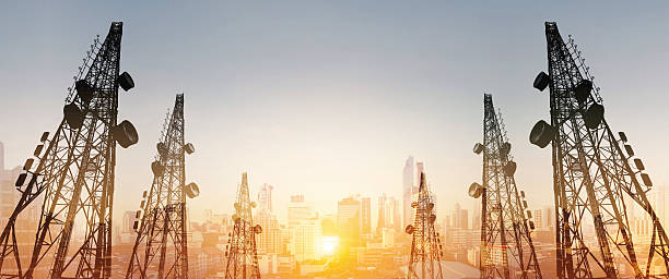 silhouette, telecommunication towers with tv antennas and cityscape in sunrise - television aerial antenna television broadcasting imagens e fotografias de stock