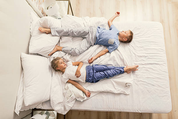 istock Brother and sister sleeping at home 625998762