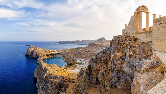 Greece. Rhodes. Acropolis of Lindos. Doric columns of the ancient Temple of Athena Lindia the IV century BC and the bay of St. Paul