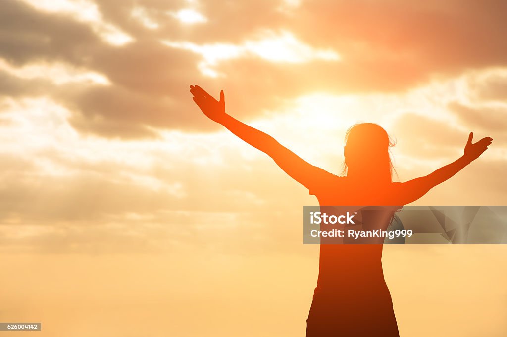 silhouette of woman pray silhouette of woman pray with sunlight Motivation Stock Photo