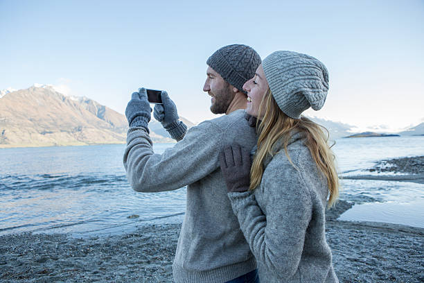 istock Two lovers by the lake take selfie using smart phone 626005994