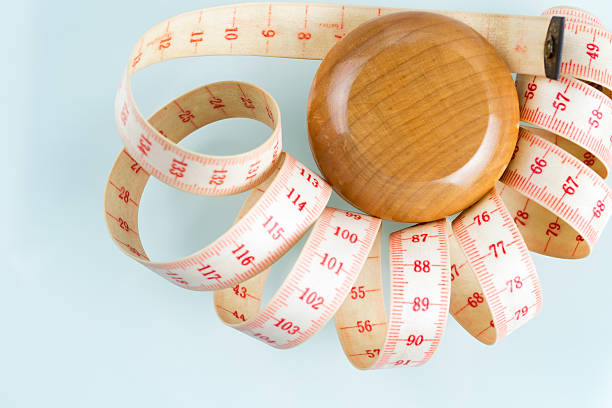 Yo-yo effect concept. Wooden yoyo with centimeter measure.