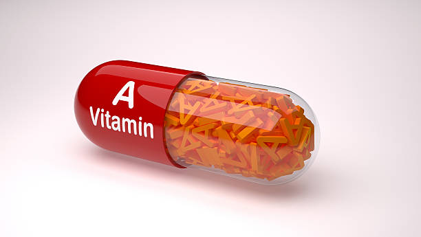 красная таблетка или капсула, наполненная витамином а. - vitamin a стоковые фото и изображения