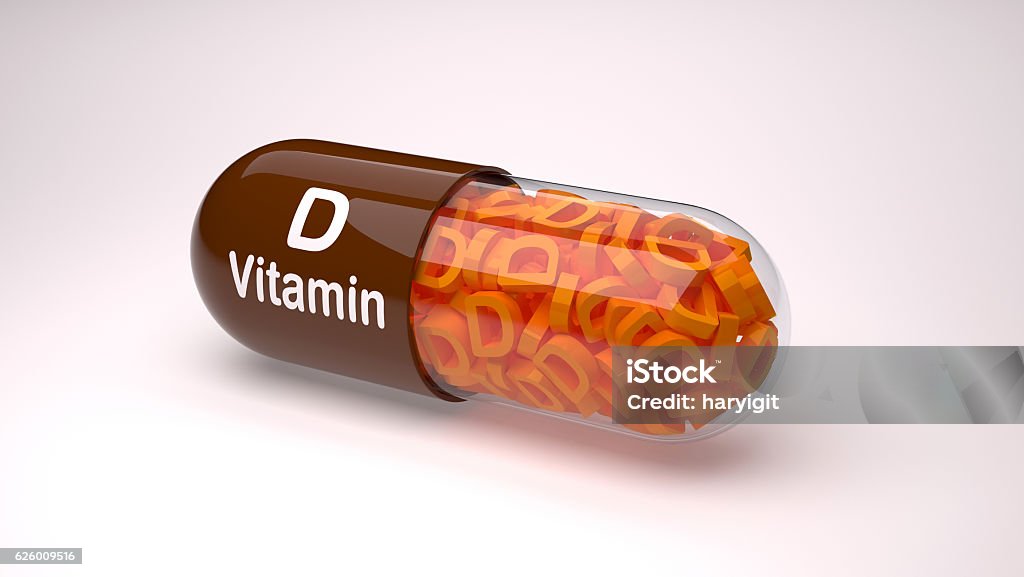 Brown pill or capsule filled with vitamin D. Vitamin capsules. Backgrounds Stock Photo