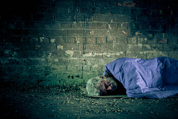 hombre caucásico sin hogar mayor que duerme a la intemperie al aire libre - brick wall homelessness wall begging fotografías e imágenes de stock