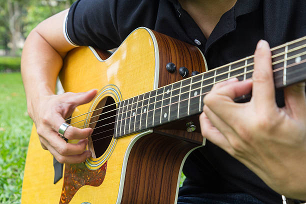 istock playing guitar in the park 626011846