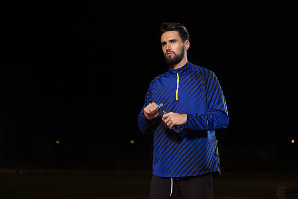 istock Athlete holding water bottle, night. 626012160