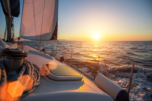 Sailing ship luxury yacht boat in the Sea during amazing sunset.