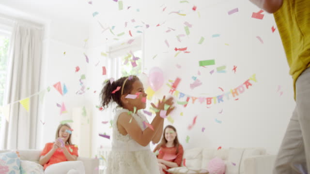 Father and daughter gathering and throwing confetti overhead at birthday party
